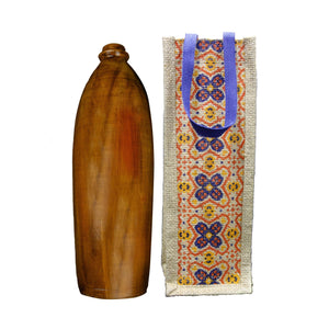 wooden bottle with polished finish next to a textile bag with colorful floral patterns and blue handles