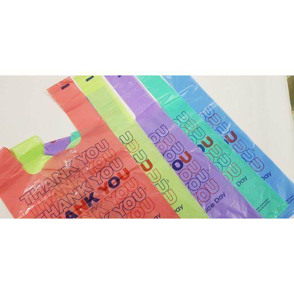 Colorful plastic bags with repeating thank you text arranged side by side on white surface